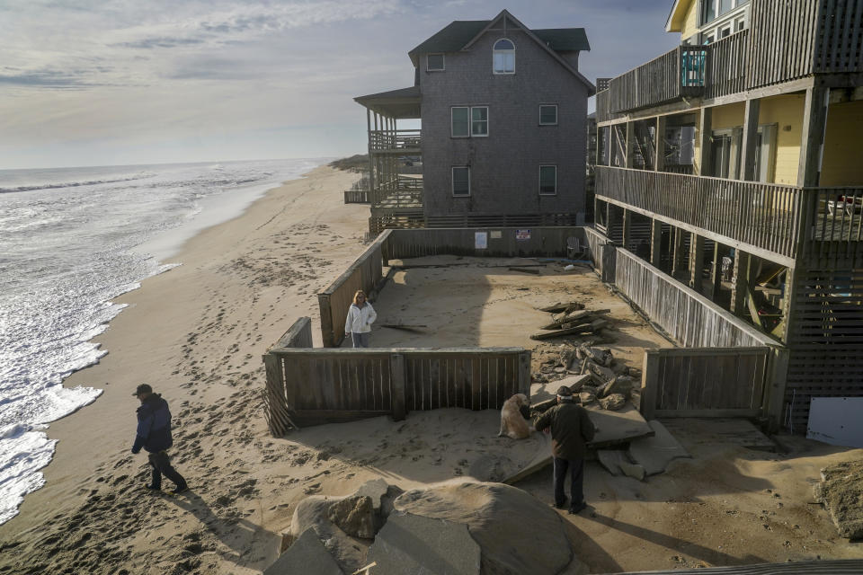 In 2022, Outer Banks residents stand where a swimming pool once stood in their backyard on the Outer Banks beach.