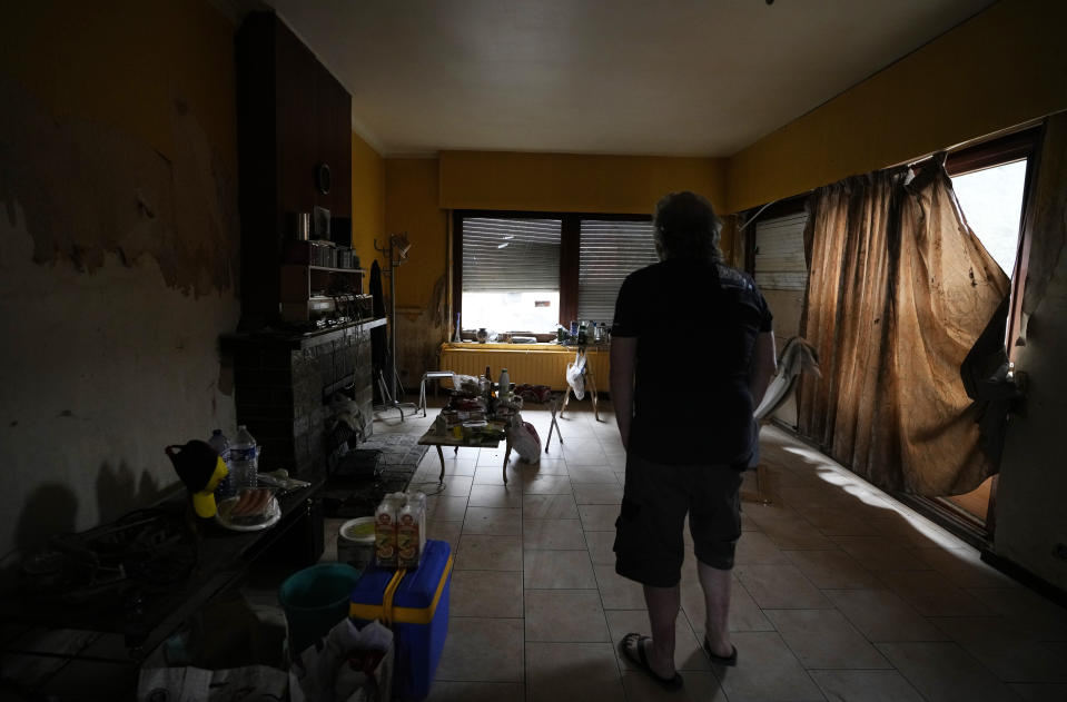 Resident Alan Mereschal stands in what is left of his home after flooding in Vaux-sous-Chevremont, Chaudfontaine, Belgium, Saturday, July 24, 2021. Mereschal, in an effort to help himself psychologically during the flooding, turned to helping others in using his language skills to help translate between residents and rescue personnel. (AP Photo/Virginia Mayo)