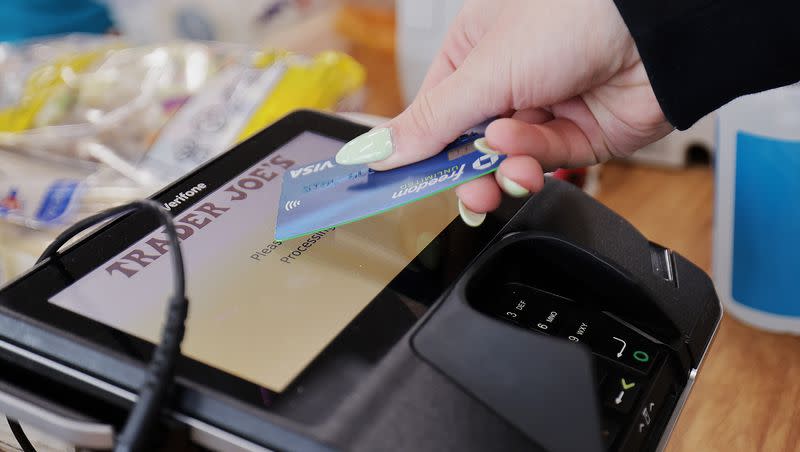 A woman uses her card to make her purchase at Trader Joe’s in Draper on March 3, 2023.