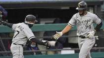 Chicago White Sox third-base coach Joe McEwing, left, congratulates Jose Abreu after Abreu hit a solo home run in the fourth inning in a baseball game against the Cleveland Indians, Tuesday, April 20, 2021, in Cleveland. (AP Photo/Tony Dejak)