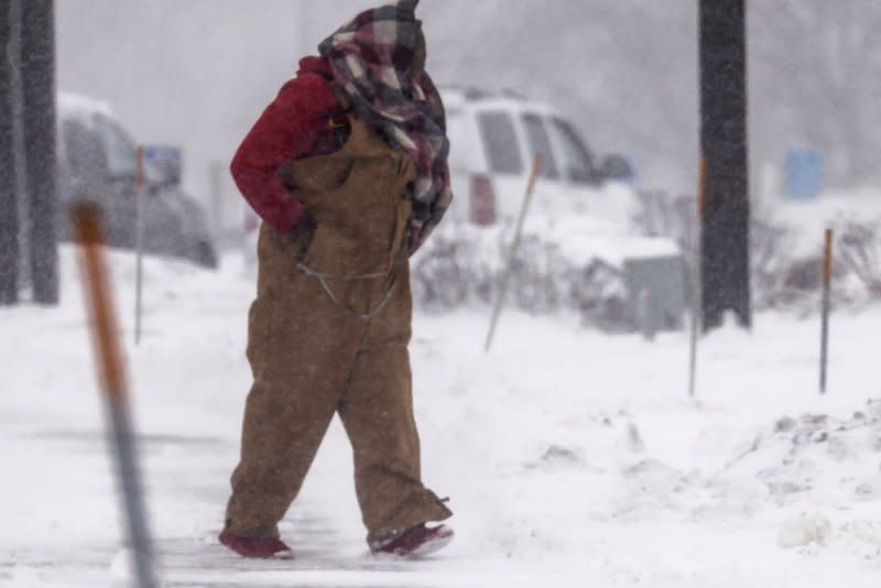 A man walks through a snowy parking lot as a severe winter storm makes life miserable and potentially dangerous in Altoona, Iowa, on Friday. Photo by Tannen Maury/UPI