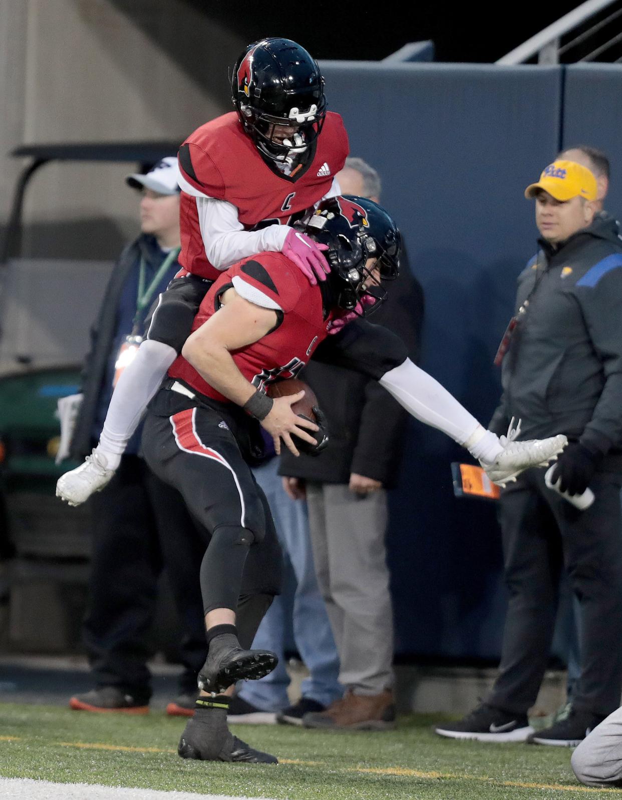 Canfield's Jack Davis jumps on the back of quarterback Broc Lowry after Lowry scored a second-half touchdown against Boom-Carroll in the Division III state final at Tom Benson Hall of Fame Stadium in Canton, Friday, Dec. 2, 2022.