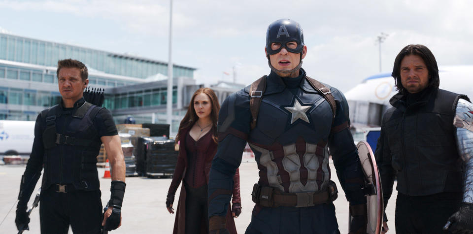 Jeremy Renner, Elizabeth Olsen, Chris Evans, and Sebastian Stan stand in a parking lot