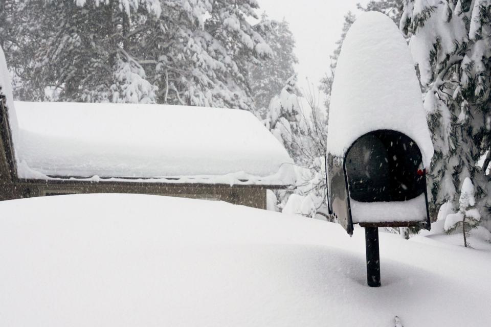 A mailbox and the roof of a home are covered in snow during a storm, Saturday, March 2, 2024, in Truckee, Calif. A powerful blizzard howled Saturday in the Sierra Nevada as the biggest storm of the season shut down a long stretch of Interstate 80 in California and gusty winds and heavy rain hit lower elevations, leaving tens of thousands of homes without power. (AP Photo/Brooke Hess-Homeier) ORG XMIT: CABH102