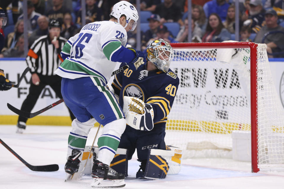 Buffalo Sabres goalie Carter Hutton (40) stops Vancouver Canucks forward Antoine Roussel (26) during the second period of an NHL hockey game Saturday, Jan. 11, 2020, in Buffalo, N.Y. (AP Photo/Jeffrey T. Barnes)