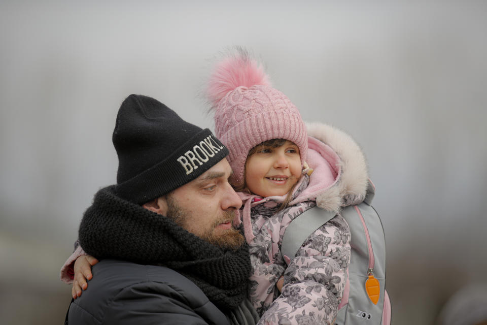 A man holds his daughter after she and her mother fled the conflict from neighbouring Ukraine at the Romanian-Ukrainian border, in Siret, Romania, Sunday, Feb. 27, 2022. Since Russia launched its offensive on Ukraine, more than 200,000 people have been forced to flee the country to bordering nations like Romania, Poland, Hungary, Moldova, and the Czech Republic — in what the U.N. refugee agency, UNHCR, said will have "devastating humanitarian consequences" on civilians. (AP Photo/Andreea Alexandru)