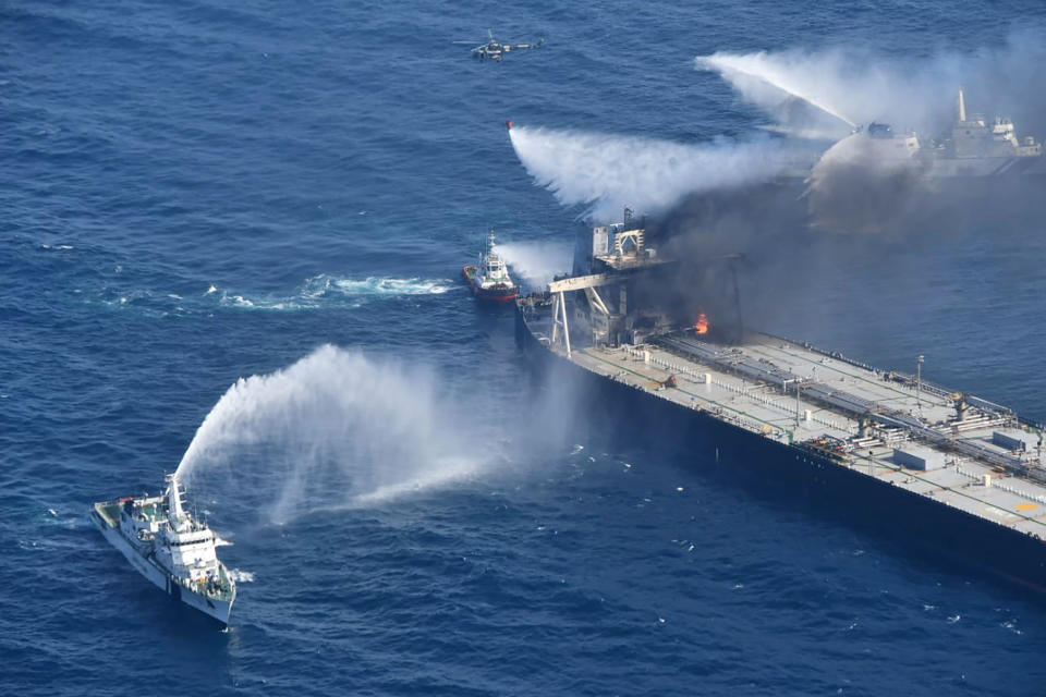 In this photo provided by Sri Lanka Air Force, tug boats and ships battle the fire on MT New Diamond, off the eastern coast of Sri Lanka in the Indian Ocean, Saturday, Sept. 5, 2020. The fire on the large oil tanker off Sri Lanka's coast has been brought under control but is still not extinguished, the navy said Saturday. The tanker, carrying nearly 2 million barrels of crude oil, was drifting about 20 nautical miles (37 kilometers) from Sri Lanka's eastern coast and on Friday evening a tug boat towed it to the deep sea away from land, said navy spokesman Capt. Indika de Silva. (Sri Lanka Air Force via AP)