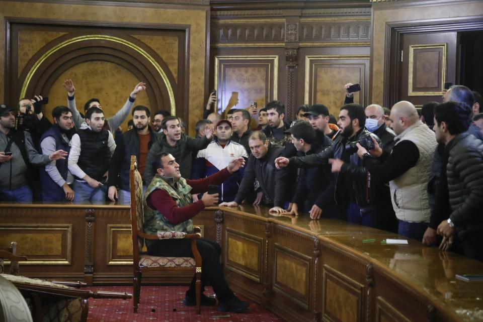 Demonstrators argue as they broke into the government building protesting against an agreement to halt fighting over the Nagorno-Karabakh region, in Yerevan, Armenia, Tuesday, Nov. 10, 2020. Armenian Prime Minister Nikol Pashinian said on Facebook that calling an end to the fight was "extremely painful for me personally and for our people." Soon after the announcement, thousands of people streamed to the main square in the Armenian capital Yerevan to protest the agreement, many shouting "We won't give up our land." Some of them broke into the main government building, saying they were searching for Pashinian, who apparently had already departed. (AP Photo/Dmitri Lovetsky)