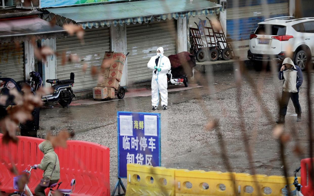 A worker in a protective suit is seen at a wet market in Wuhan in January 2020. Initially, it was thought that the first cluster of cases were linked to the market - REUTERS