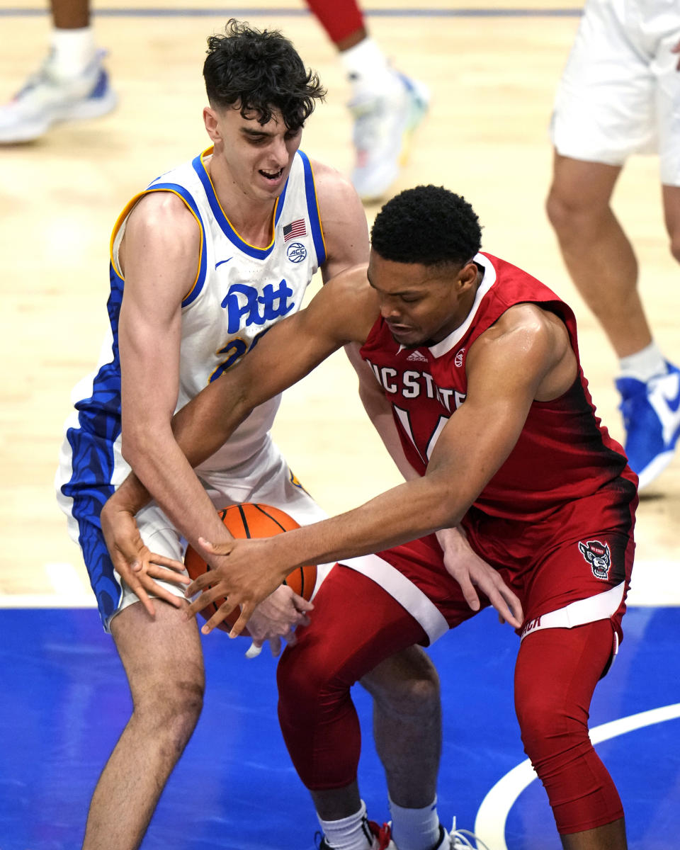 Pittsburgh's Guillermo Diaz Graham, left, steals the ball from North Carolina State's Casey Morsell during the first half of an NCAA college basketball game in Pittsburgh on Saturday, March 9, 2024. (AP Photo/Gene J. Puskar)