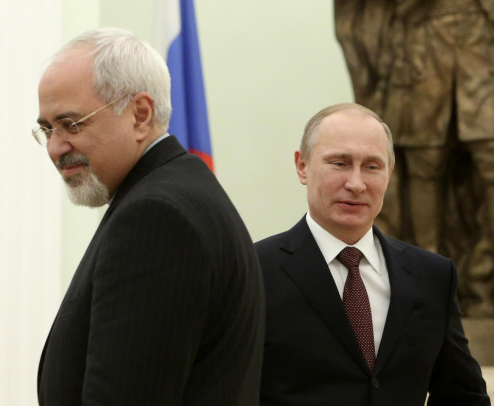 Russian President Vladimir Putin, right, passes by Iranian Foreign Minister Mohammad Javad Zarif during their meeting in the Kremlin in Moscow, Russia, Thursday, Jan. 16, 2014. Putin credited Tehran for the success of international talks on the Iranian nuclear program and called for boosting Russian-Iranian trade. (AP Photo/Sergei Karpukhin, Pool)