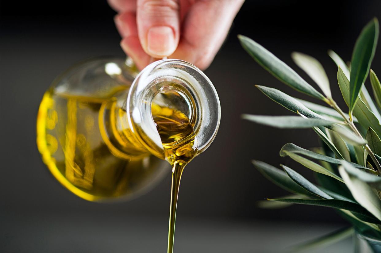 person pouring olive oil