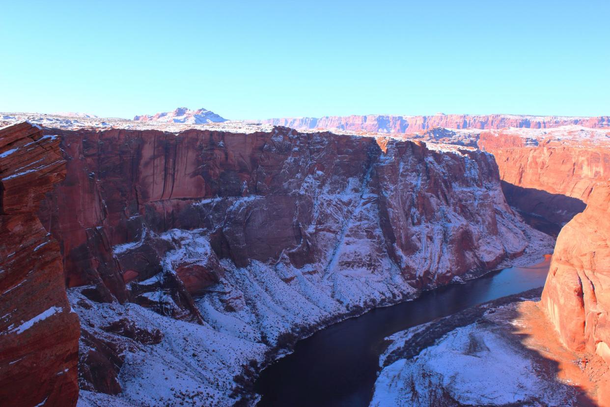 Horseshoe bend Colorado river flowing through Red sandstone rocks covered in snow in winter