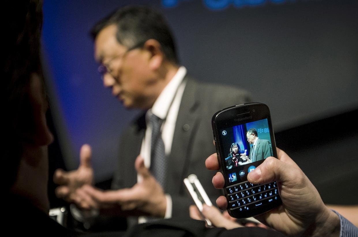 A reporter uses a Blackberry device to photograph Blackberry CEO John Chen as he speaks to reporters following their annual general meeting for shareholders in Waterloo, Canada in this June 23, 2015. REUTERS/Mark Blinch