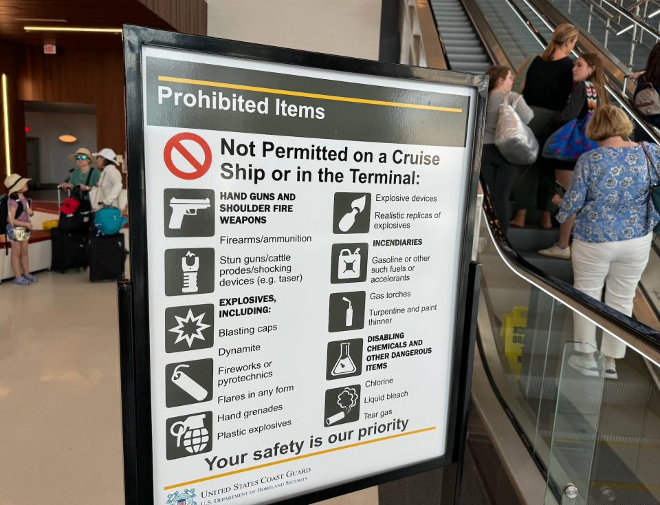 photo of sign listing prohibited items to bring on a cruise ship placed in front of an escalator