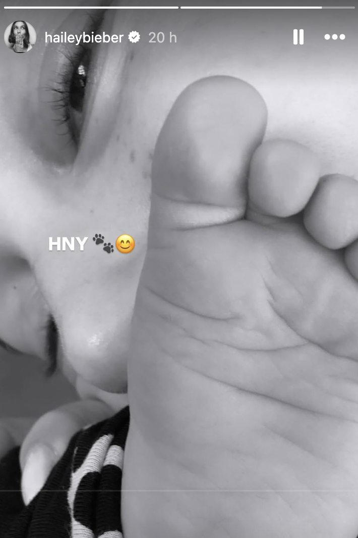 Close-up of a person gently touching a baby's foot with 