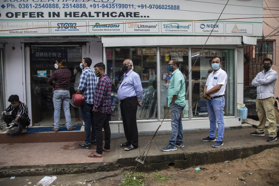 Indians wearing face masks as a precaution against the coronavirus line up outside a pharmacy to buy medicines in Gauhati, India, Thursday, May 6, 2021. Infections in India hit another grim daily record on Thursday as demand for medical oxygen jumped seven-fold and the government denied reports that it was slow in distributing life-saving supplies from abroad. (AP Photo/Anupam Nath)