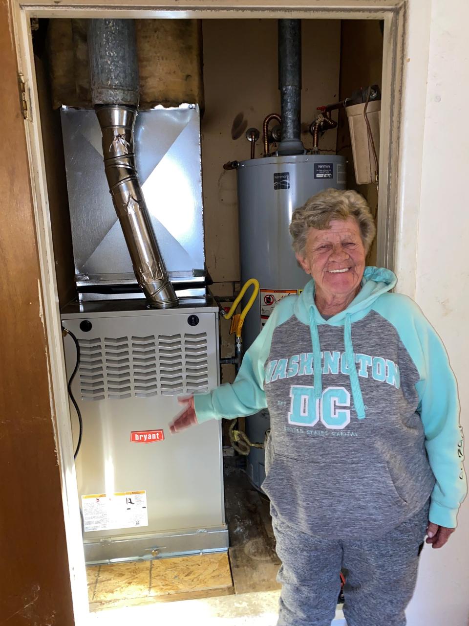 One or the winners in a giveaway program presented Robbins Heating & Air Conditioning Inc. shows off her new furnace.