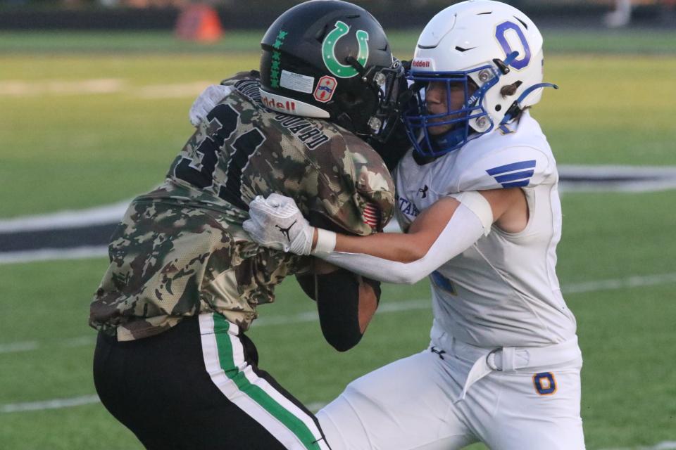 Clear Fork's Kasey Swank is met head on by Ontario's Braylon Wilson during the Warriors' 45-0 win over the Colts on Friday night.