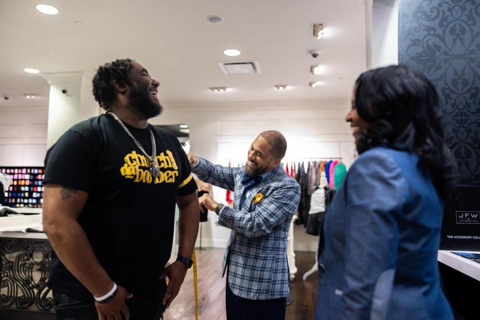 Darrius Williams, center, measures Travis Eggleston, a barber at the Grooming Lounge, on March 13, 2024, at D. Williams Suits at Northlake Mall in Charlotte.