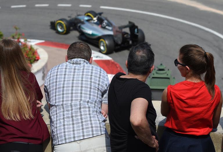 People watch as Mercedes AMG Petronas F1 Team's British driver Lewis Hamilton drives at the Monaco street circuit in Monte-Carlo on May 24, 2015, during the Monaco Formula One Grand Prix