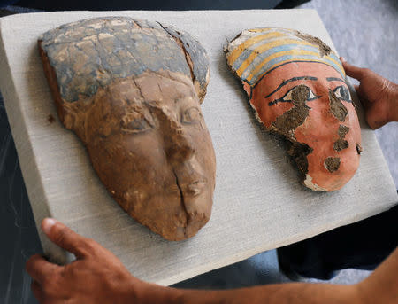 Archaeological worker carries mask artefacts outside the tomb of Khufu-Imhat, at the Saqqara area near its necropolis, in Giza, Egypt November 10, 2018. REUTERS/Mohamed Abd El Ghany