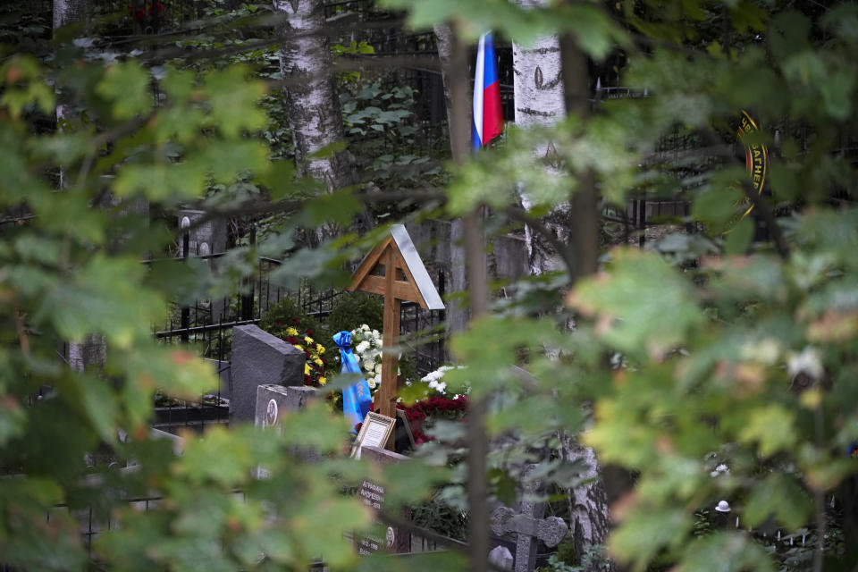 Russian flag is seen above the grave of Wagner Group's chief Yevgeny Prigozhin after a funeral at the Porokhovskoye cemetery in St. Petersburg, Russia, Tuesday, Aug. 29, 2023. The Kremlin says Russian President Vladimir Putin isn't planning to attend the funeral of Yevgeny Prigozhin, who died last week in a plane crash two months after launching his brief rebellion. (AP Photo/Dmitri Lovetsky)