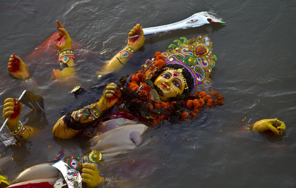 ARCHIVO - En esta fotografía de archivo del 8 de octubre de 2019, un ídolo de la diosa hindú Durga flota en el río Brahmaputra después de que se sumergiera marcando el final de las festividades de Durga Puja en Gauhati, India. El festival conmemora el asesinato de un rey demonio a manos de la diosa Durga, montada en leones, diez armados, marcando el triunfo del bien sobre el mal. (Foto AP / Anupam Nathv, archivo)