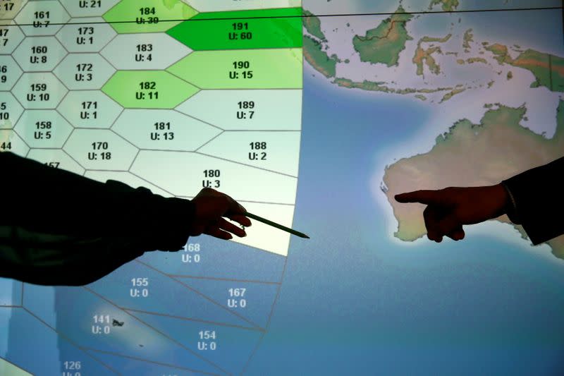 FILE PHOTO: Member of staff at satellite communications company Inmarsat point to a section of the screen showing the southern Indian Ocean to the west of Australia, at their headquarters in London