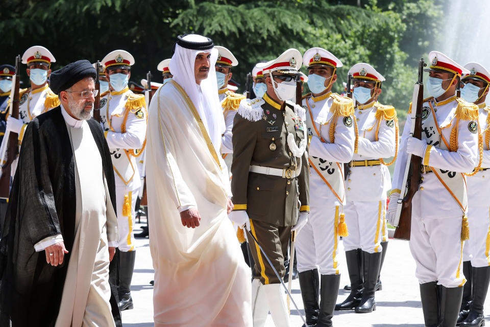 In this photo released by the official website of the office of the Iranian Presidency, Qatari Emir Sheikh Tamim bin Hamad Al Thani, second left, reviews an honor guard as he is welcomed by President Ebrahim Raisi, left, during an official arrival ceremony at the Saadabad Palace in Tehran, Iran, Thursday, May 12, 2022. Qatar's emir arrived in Tehran for talks with the Iranian president as efforts to save Tehran's tattered nuclear deal with world powers hit a deadlock. (Iranian Presidency Office via AP)