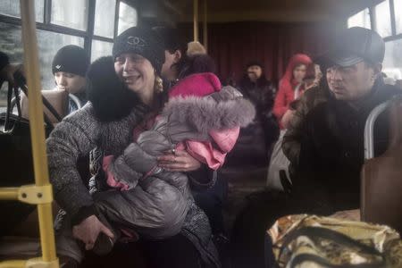 People sit inside a bus before the departure, as they flee due to the military conflict, in Debaltseve, February 3, 2015. REUTERS/Sergey Polezhaka