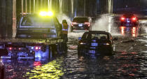 Isaac Brown's commute through downtown Atlanta, on Wednesday, Nov. 30, 2022, was derailed after his Honda stalled out in knee-deep water on North Avenue at State Street. "Just my luck," Brown said Wednesday as he waited for his car to be pulled out of the water. "Trying to rush into work, I thought I could make it through these flood waters and I stalled out." (John Spink/Atlanta Journal-Constitution via AP)