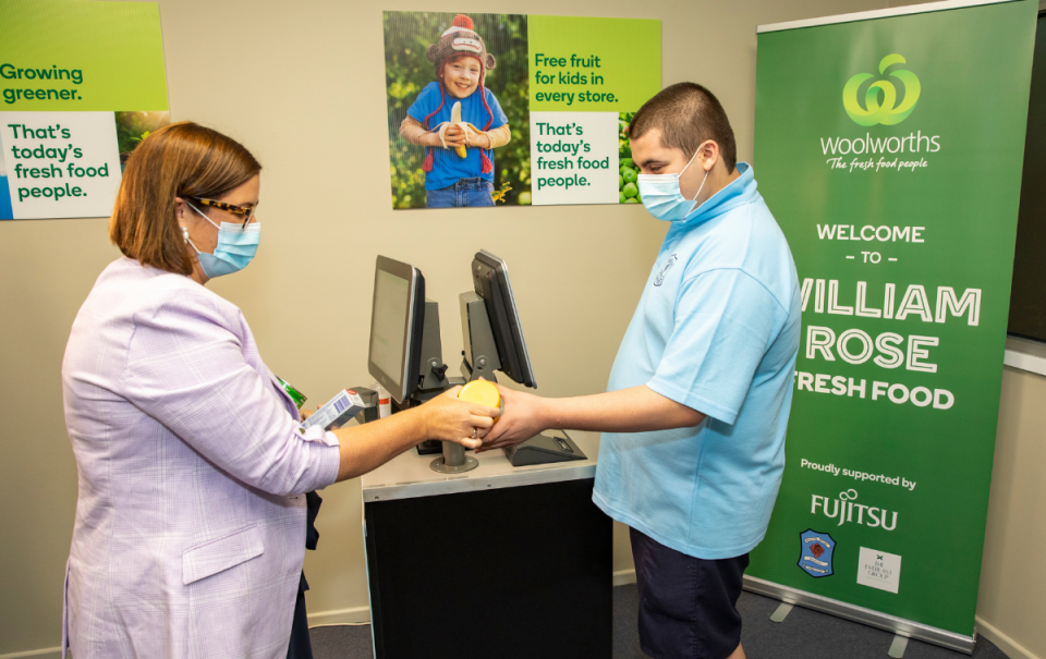 Student serving a customer at the Mini Woolworths supermarket