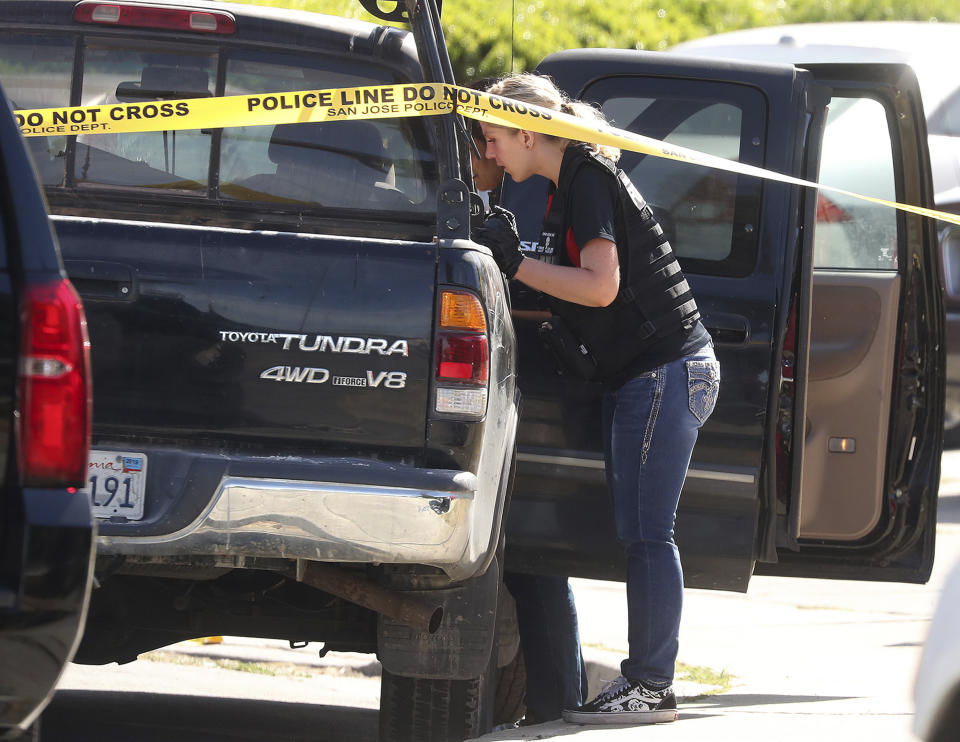 A forensic analyst with the San Jose Police Department searches a truck near scene where five people were killed Monday, June 24, 2019, in San Jose, Calif. A gunman shot and killed four people then turned the gun on himself after an hours-long standoff with police in California, authorities said Monday. San Jose police saw several family members fleeing a home when police responded to multiple calls of shots fired Sunday night. (Aric Crabb/Bay Area News Group via AP)