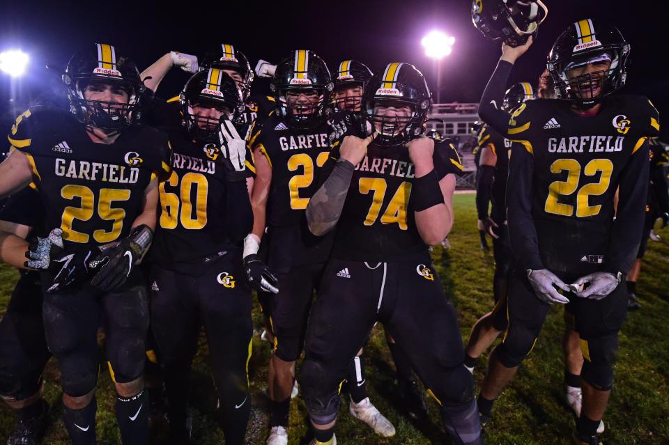 Garfield's Anthony Demma (25), Shawn Barber (60), Noah Eggert (23), Riley LaPorte (74) and Joe Perrine (22) celebrate after Garfield defeated Cardinal Mooney 24-21 in their OHSAA playoff game Saturday night.