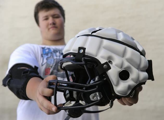 A Columbine freshman shows a Guardian Cap atop his helmet, which will be illegal in Colorado games — Denver Post