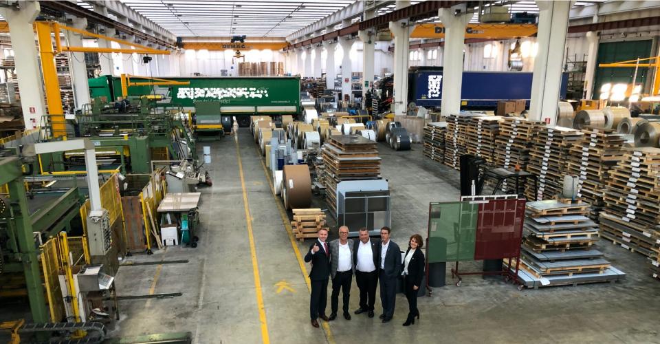 Brad Bookout, Maurizio Tamborin, James King, Bill Walters, and Sabrina Riccardi are photographed inside an INOX facility in Italy.