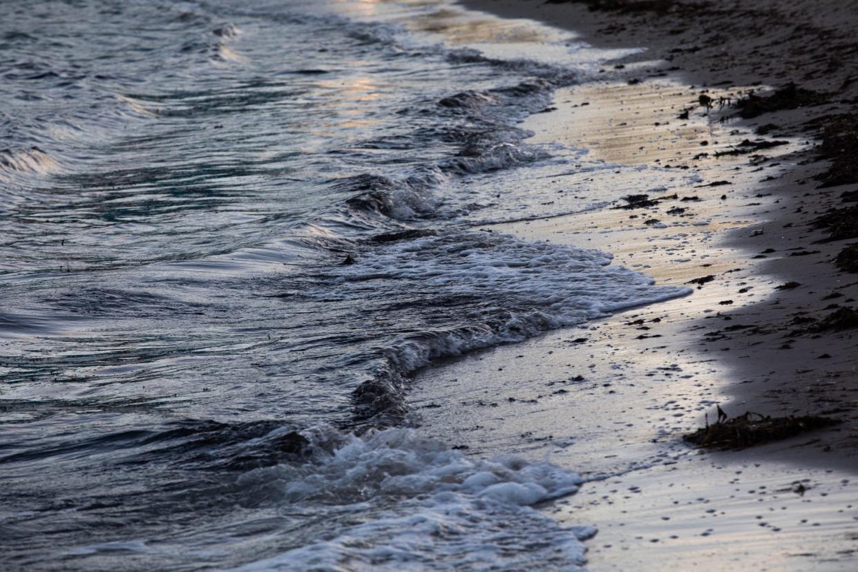 Bay water laps onto a shore on North Beach on June 25 in Corpus Christi.