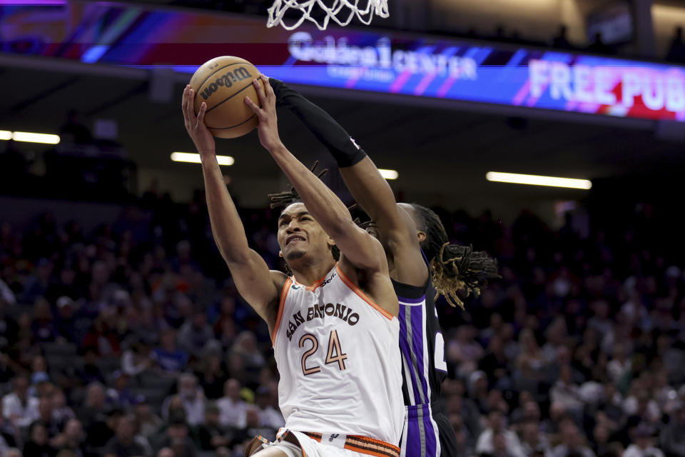 San Antonio Spurs guard Devin Vassell (24) shoots against Sacramento Kings guard Keon Ellis during the second half of an NBA basketball game Thursday, March 7, 2024, in Sacramento, Calif. (AP Photo/Jed Jacobsohn)