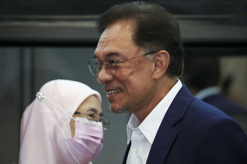 Malaysia opposition leader Anwar Ibrahim and his wife Wan Azizah Wan Ismail react after a news conference in Kuala Lumpur