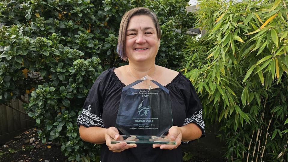 Woman in a black top holding a glass award