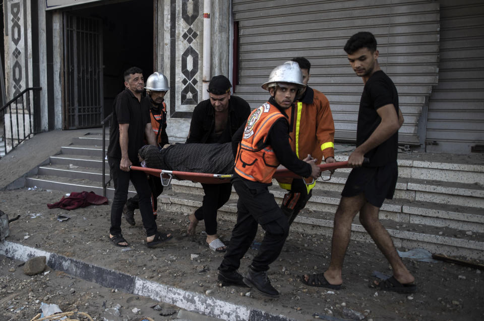 Palestinian rescuers evacuate an elderly woman from a building following Israeli airstrikes on Gaza City, Wednesday, May 12, 2021. Rockets streamed out of Gaza and Israel pounded the territory with airstrikes early Wednesday as the most severe outbreak of violence since the 2014 war took on many of the hallmarks of that devastating 50-day conflict, with no endgame in sight. (AP Photo/Khalil Hamra)