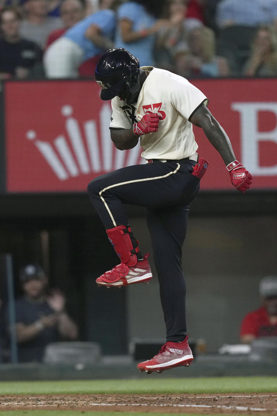 Texas Rangers' Adolis Garcia jumps onto home plate after hitting a two-run home run during the fourth inning of a baseball game against the Colorado Rockies in Arlington, Texas, Friday, May 19, 2023. Rangers' Nathaniel Lowe also scored on the play. (AP Photo/LM Otero)