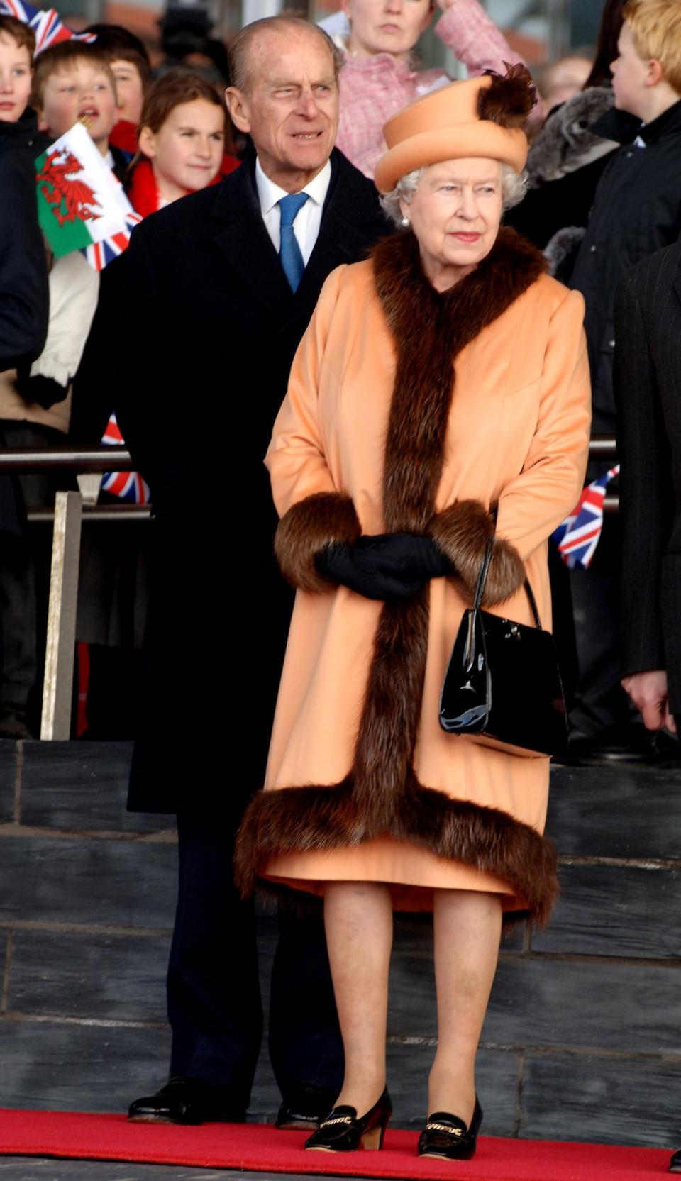 <p>The Queen cosied up in an orange coat and hat lined with luxurious fur.<br><i>[Photo: PA]</i> </p>