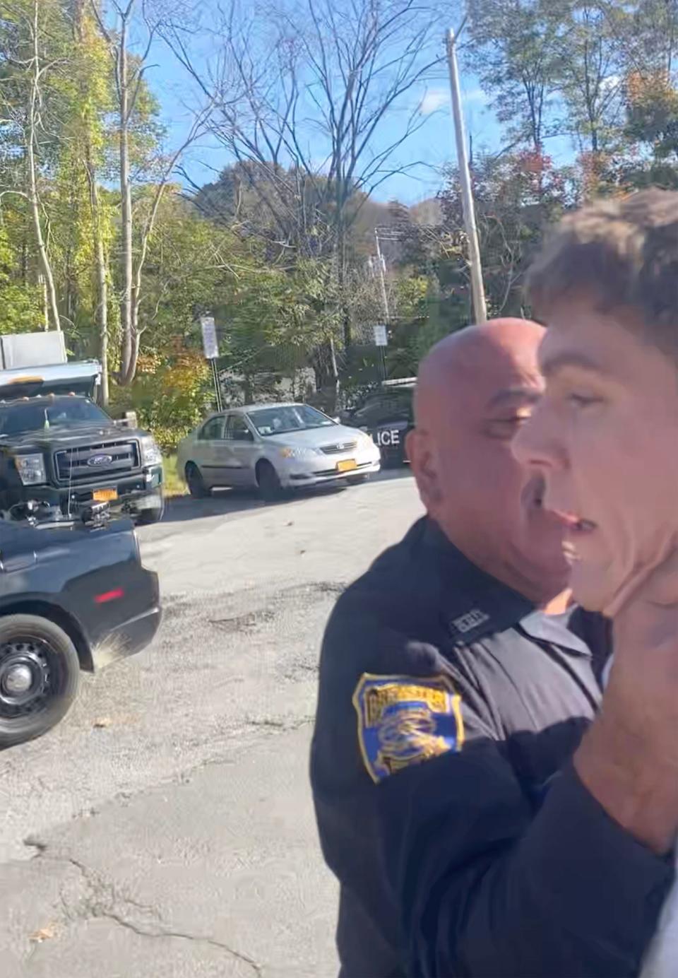 A screenshot from a cellphone video taken by Alexander King shows Brewster police Officer Fernando Quinones with his right hand at King's neck during an arrest in the parking lot at police headquarters on Oct. 28, 2021.