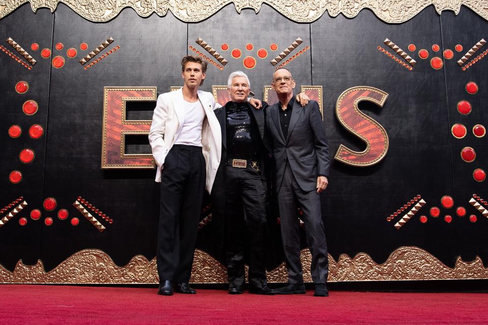 Austin Butler (left) plays Elvis Presley in the new biopic "Elvis," directed by Baz Luhrmann (center) and co-starring Tom Hanks (right) as Colonel Tom Parker.