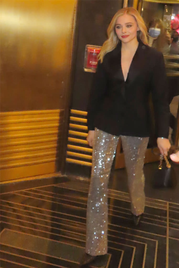 Chloë Grace Moretz wearing a black blazer with sparkly pants and pointed-toe shoes at NBC studios Dec, 7. - Credit: Rick Davis / SplashNews.com