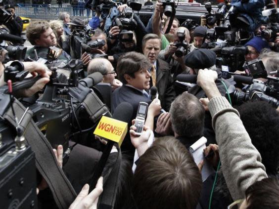 Rod Blagojevich, centre, fights his way through the media scrum as he leaves the federal court in Chicago (AP)