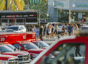 <p>A Los Angeles Police SWAT team escorts a group of people who were held for their safety across businesses surrounding Trader Joe’s supermarket, after a gunman had barricaded himself inside a Trader Joe’s store in Los Angeles on Saturday. (Photo: Damian Dovarganes/AP) </p>