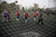 In this Wednesday, April 24, 2019 photo, members of Hestia FC Women's Refugee Soccer team practise during a training session in Athens. Many of the players at Hestia FC weren't allowed to play or even watch soccer matches in their home countries. Hestia FC was set up by the Olympic Truce Centre, a non-government organization created in 2000 by the International Olympic Committee and Greek Foreign Ministry. (AP Photo/Thanassis Stavrakis)
